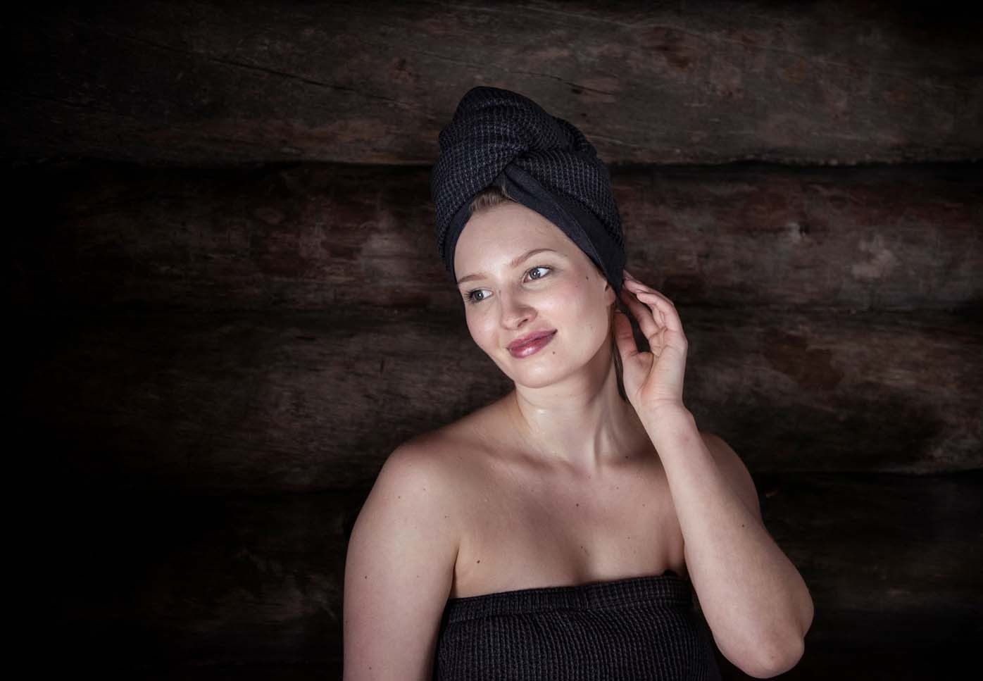Kvinde i sauna med et hårhåndklæde