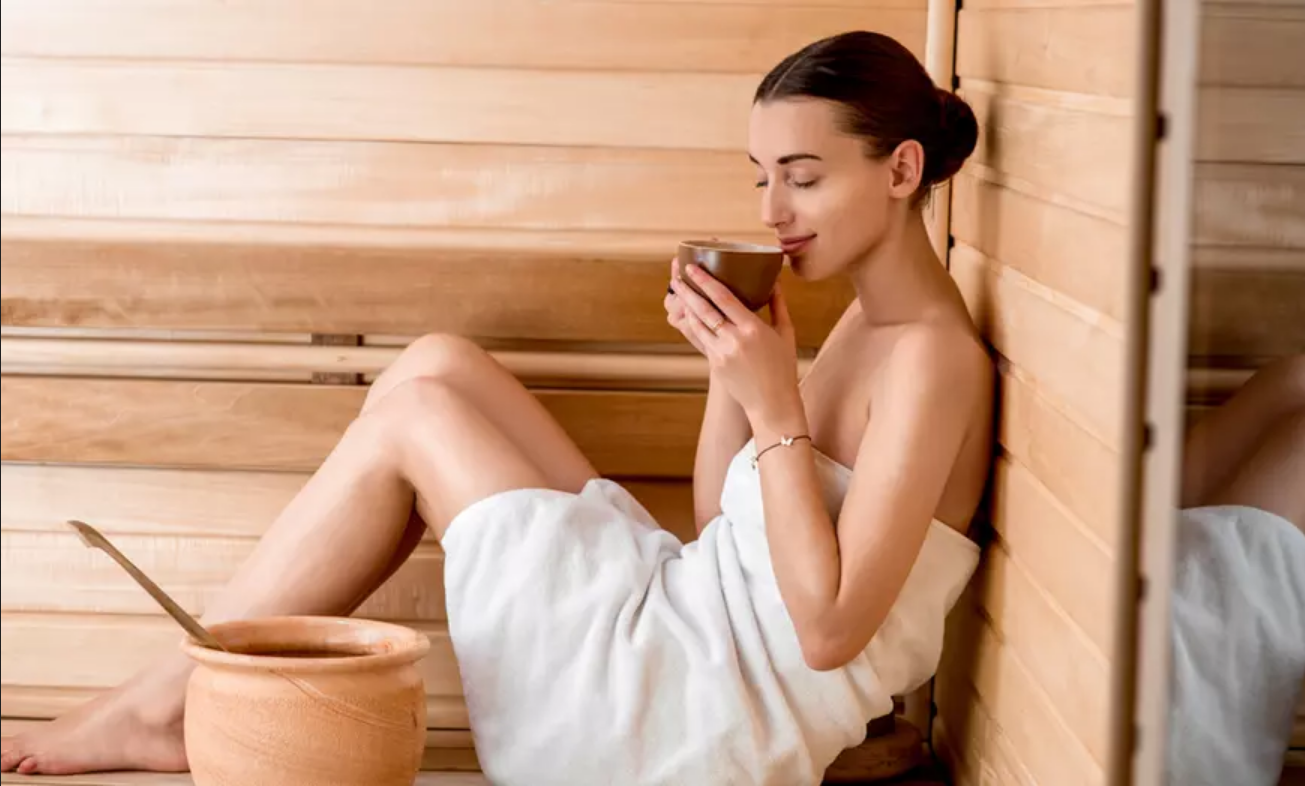 En kvinde drikker te i en sauna