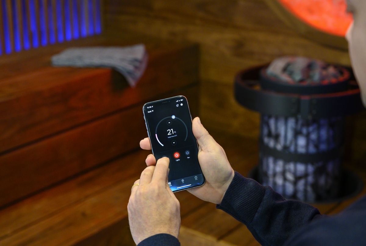 person, der styrer saunaudstyr med MyHarvia-mobilappen